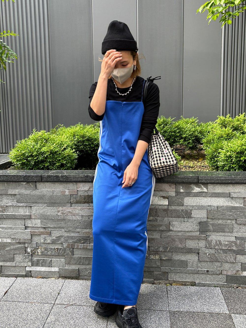 ブルー系のワンピース、ホワイト系のナイロンジャケットを着用したレディースの春コーディネートの4枚目の写真