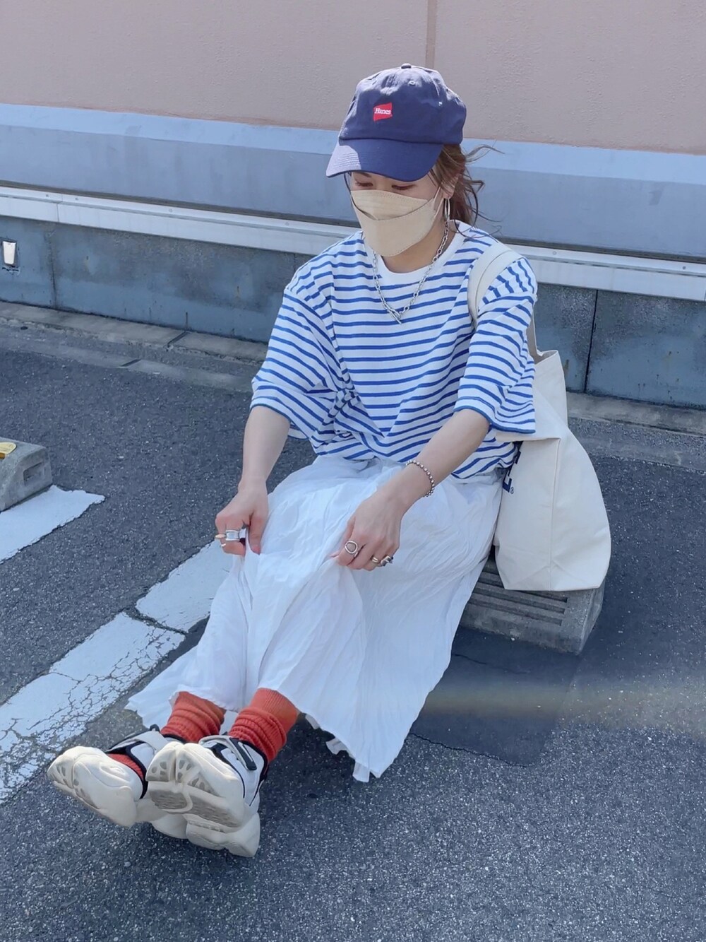 ブルー系のTシャツ/カットソー、ホワイト系のトートバッグ、ホワイト系のスカートを着用したレディースの春コーディネートの2枚目の写真