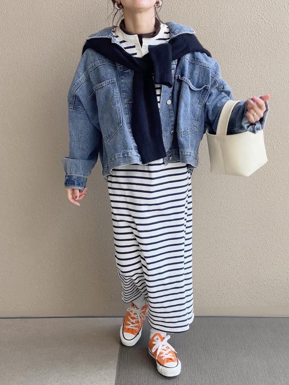 ホワイト系のワンピース/ドレス、ブルー系のデニムジャケット、オレンジ系のスニーカーを着用したレディースの冬コーディネートの3枚目の写真