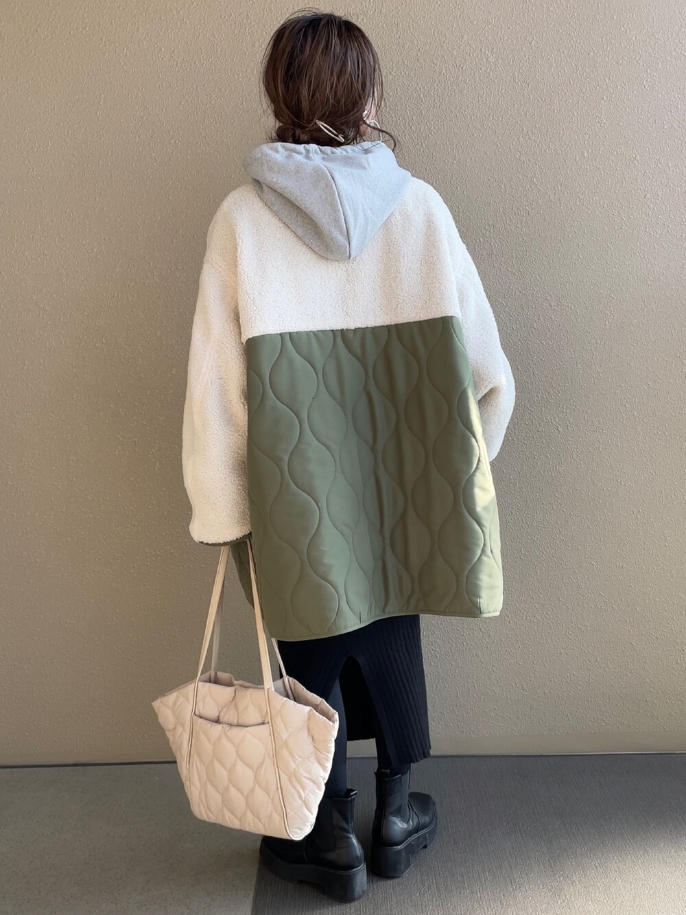 グリーン系のノーカラージャケット、グレー系のパーカー、ベージュ系のトートバッグを着用したレディースの冬コーディネートの2枚目の写真