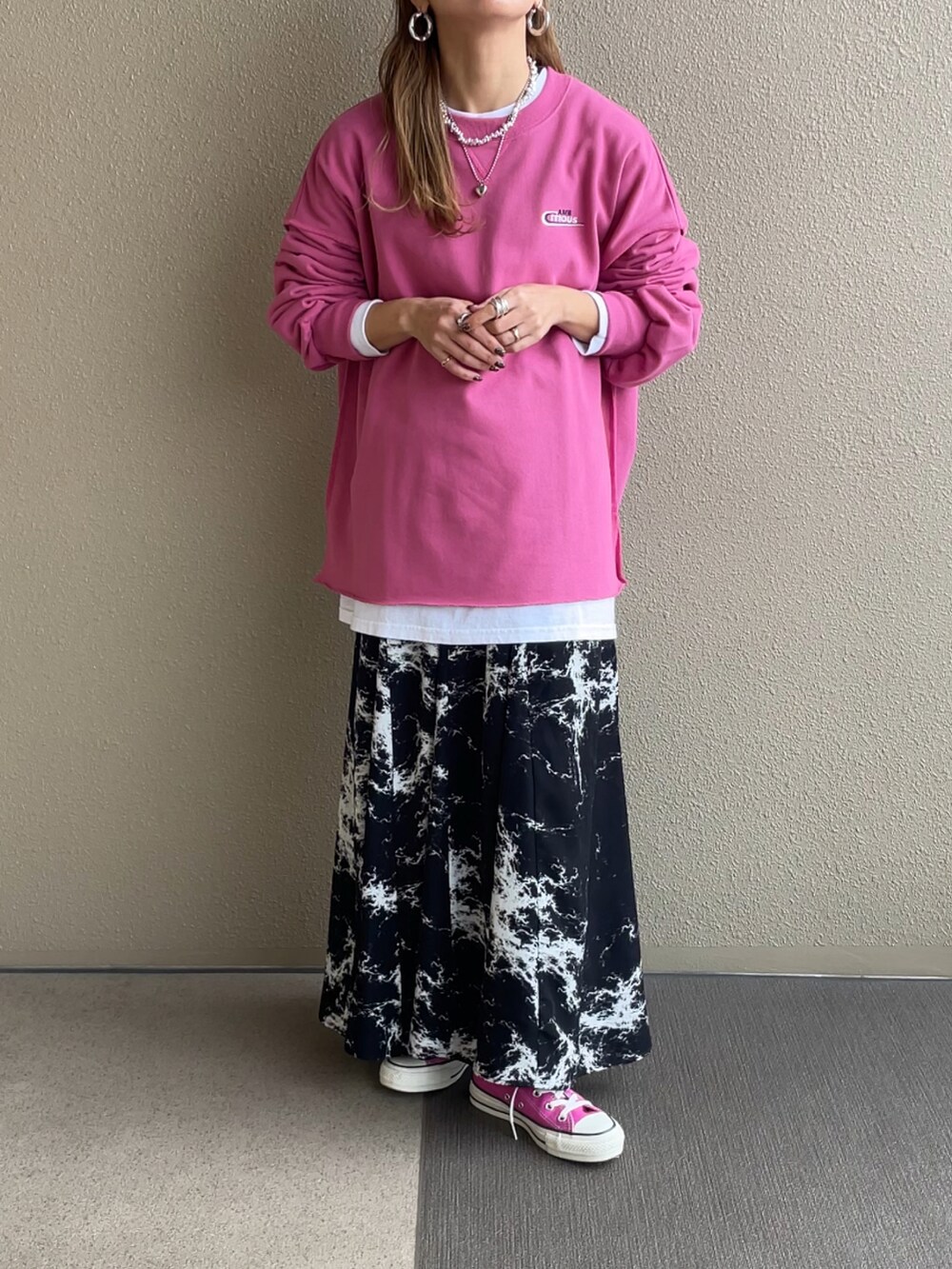 ピンク系のスウェット、ブラック系のスカートを着用したレディースの冬コーディネートの2枚目の写真