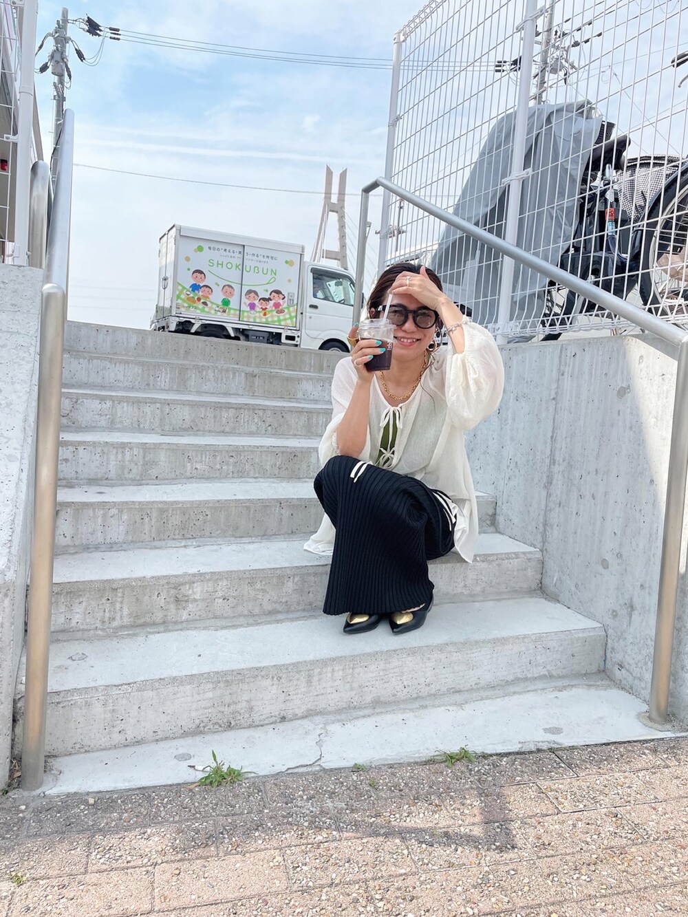 ホワイト系のシャツ/ブラウス、ブラック系のスカート、ブラック系のパンプスを着用したレディースの夏コーディネートの3枚目の写真