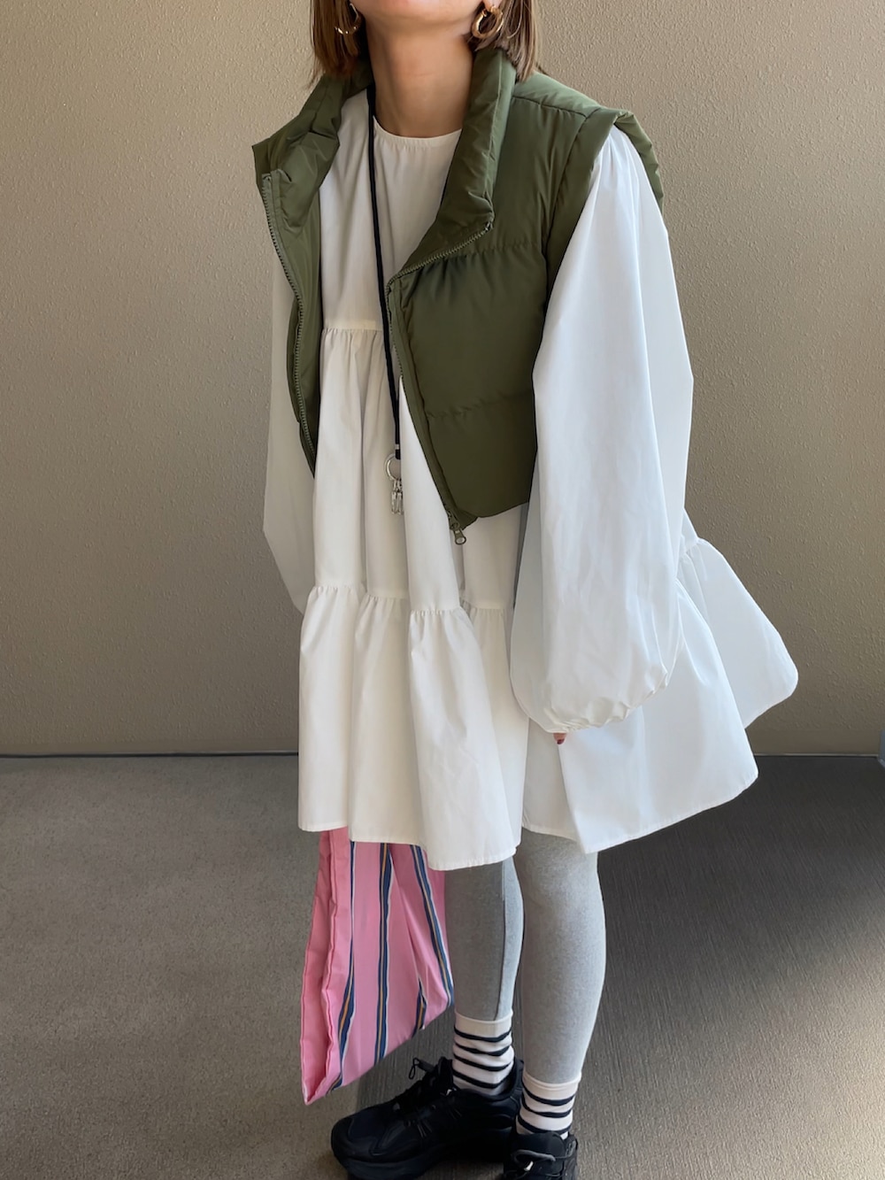 ホワイト系のシャツ/ブラウス、グリーン系のベスト、グレー系のレギンス/スパッツを着用したレディースの冬コーディネートの2枚目の写真