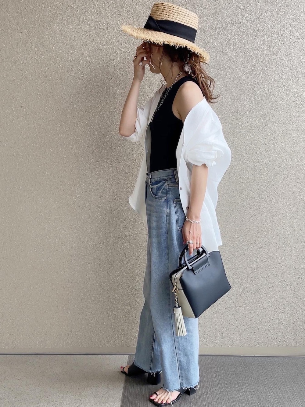 ブラック系のショルダーバッグ、ホワイト系のシャツ/ブラウス、ブラック系のタンクトップを着用したレディースの春コーディネートの2枚目の写真