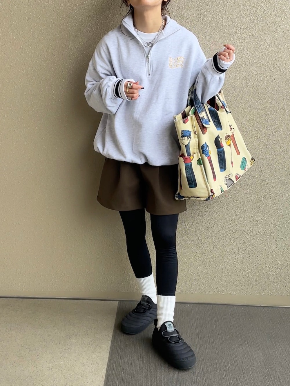 ベージュ系のスウェット、ブラウン系のパンツ、ホワイト系のトートバッグを着用したレディースの冬コーディネートの4枚目の写真