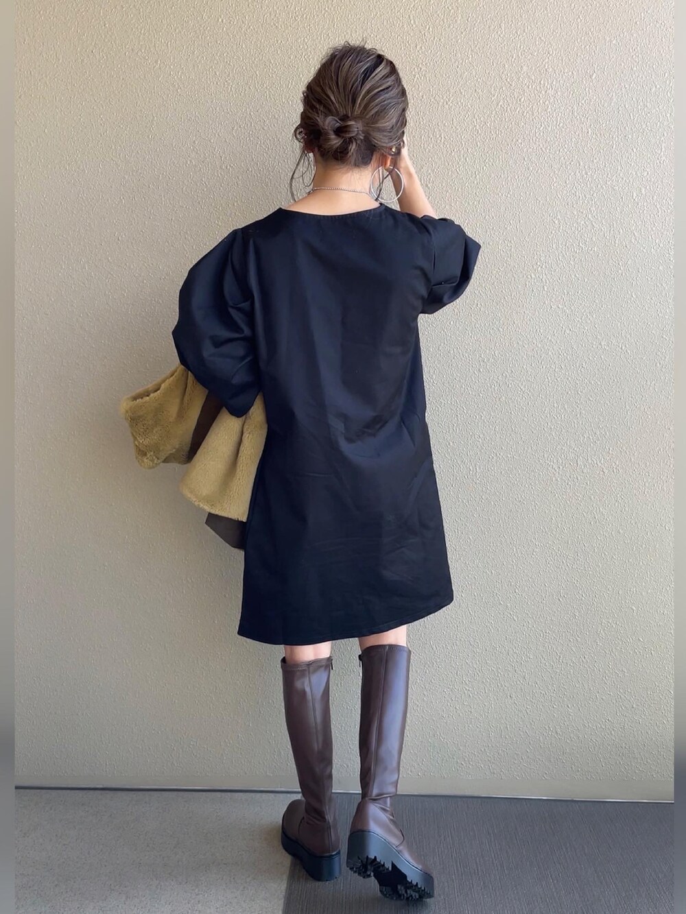 ブラック系のワンピース、イエロー系のベスト、ブラウン系のブーツを着用したレディースの秋コーディネートの4枚目の写真