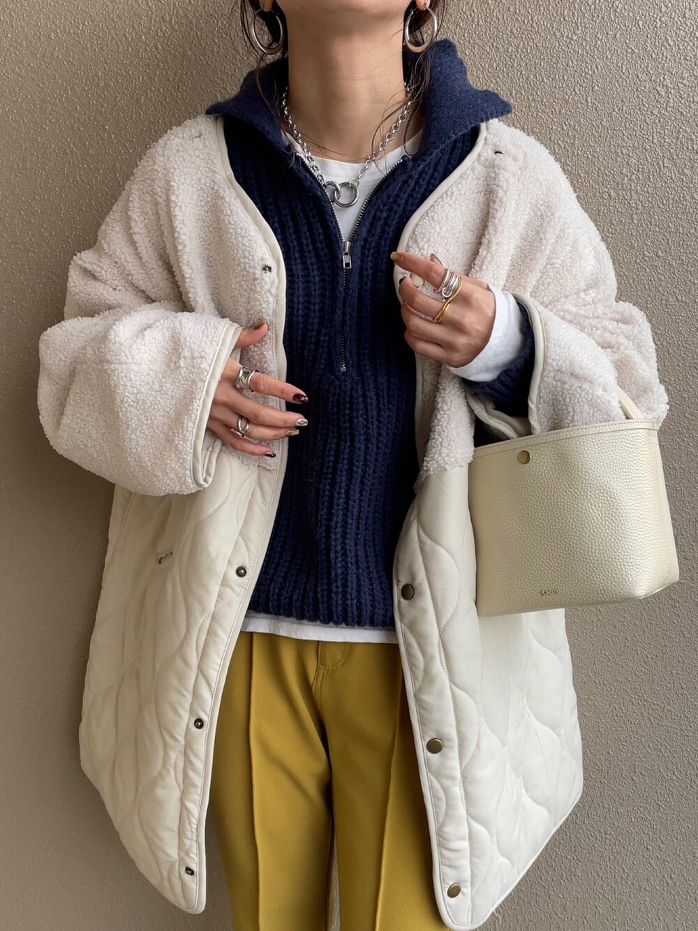 ホワイト系のノーカラージャケット、ブルー系のニット/セーター、イエロー系のその他パンツを着用したレディースの冬コーディネートの3枚目の写真