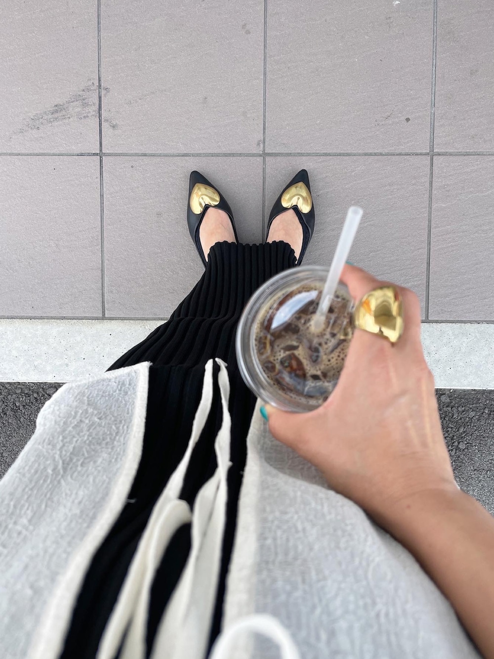 ホワイト系のシャツ/ブラウス、ブラック系のスカート、ブラック系のパンプスを着用したレディースの夏コーディネートの4枚目の写真