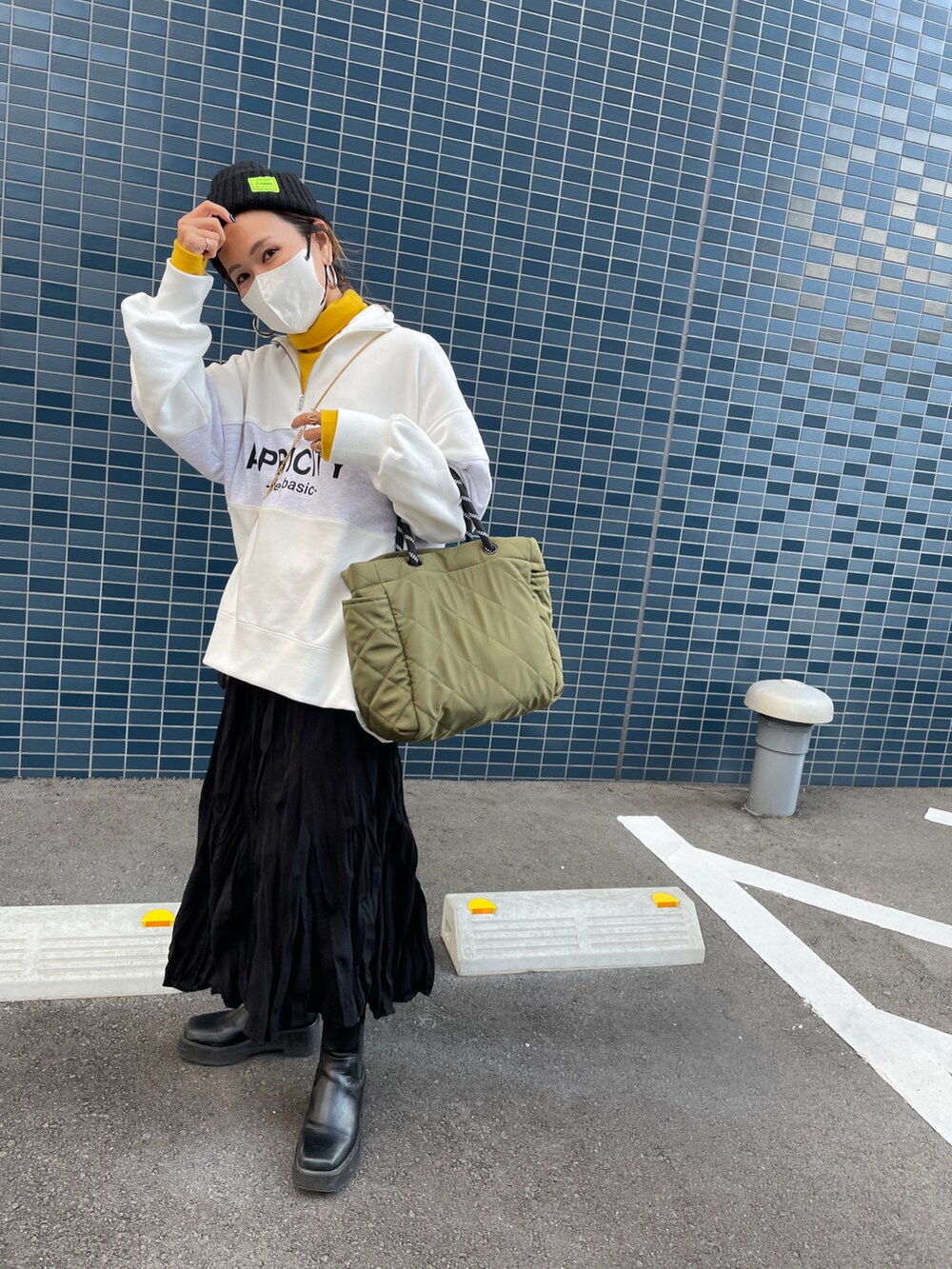 ブラック系のスカート、グリーン系のショルダーバッグ、ホワイト系のスウェットを着用したレディースの秋コーディネートの2枚目の写真