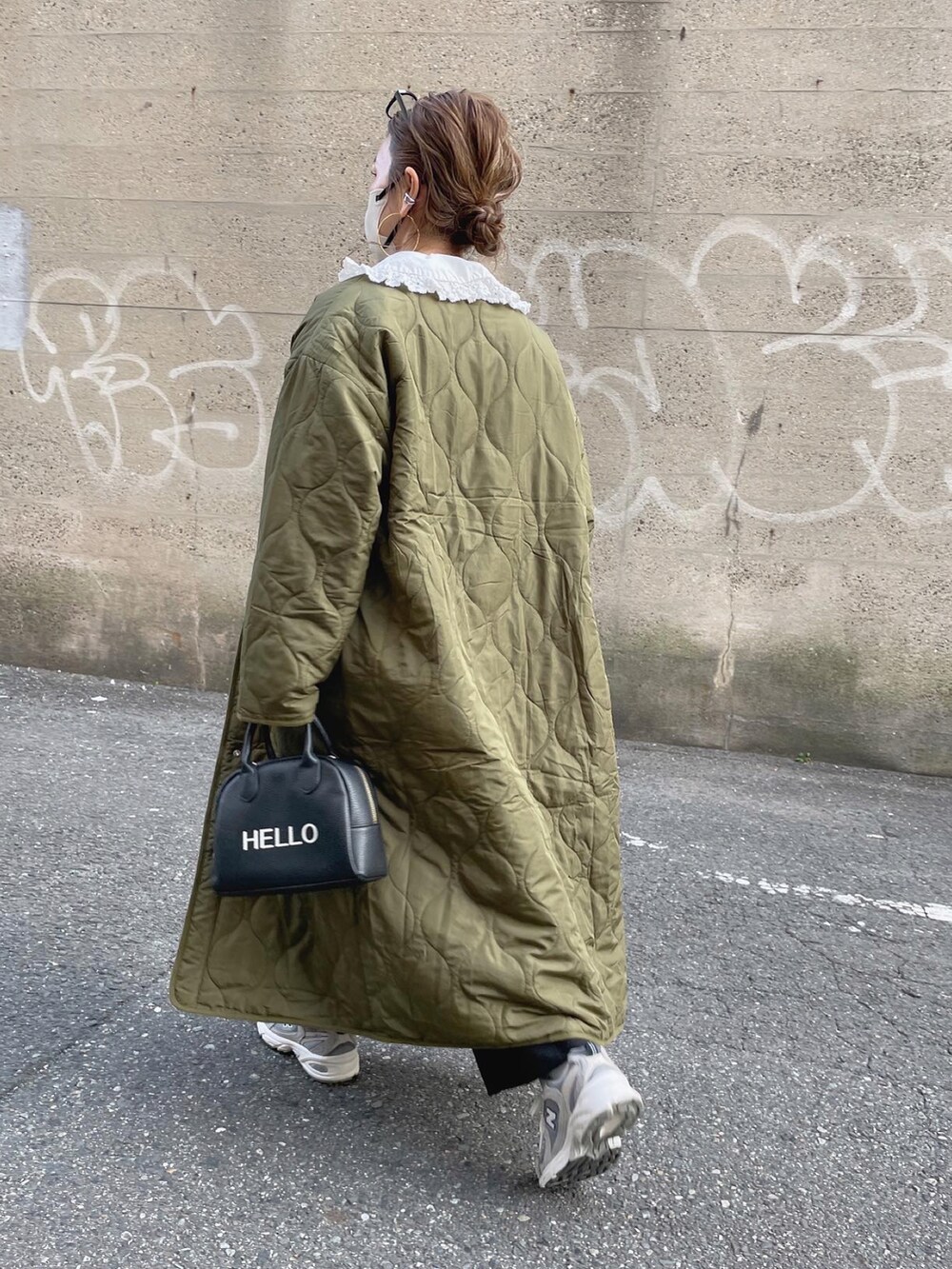 グレー系のスウェット、グリーン系のノーカラーコート、ブラック系のスラックスを着用したレディースの冬コーディネートの2枚目の写真