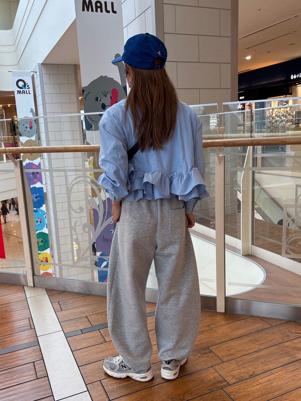 グレー系のセットアップ、ブルー系のTシャツ/カットソー、ブルー系のキャップを着用したレディースの春コーディネートの2枚目の写真
