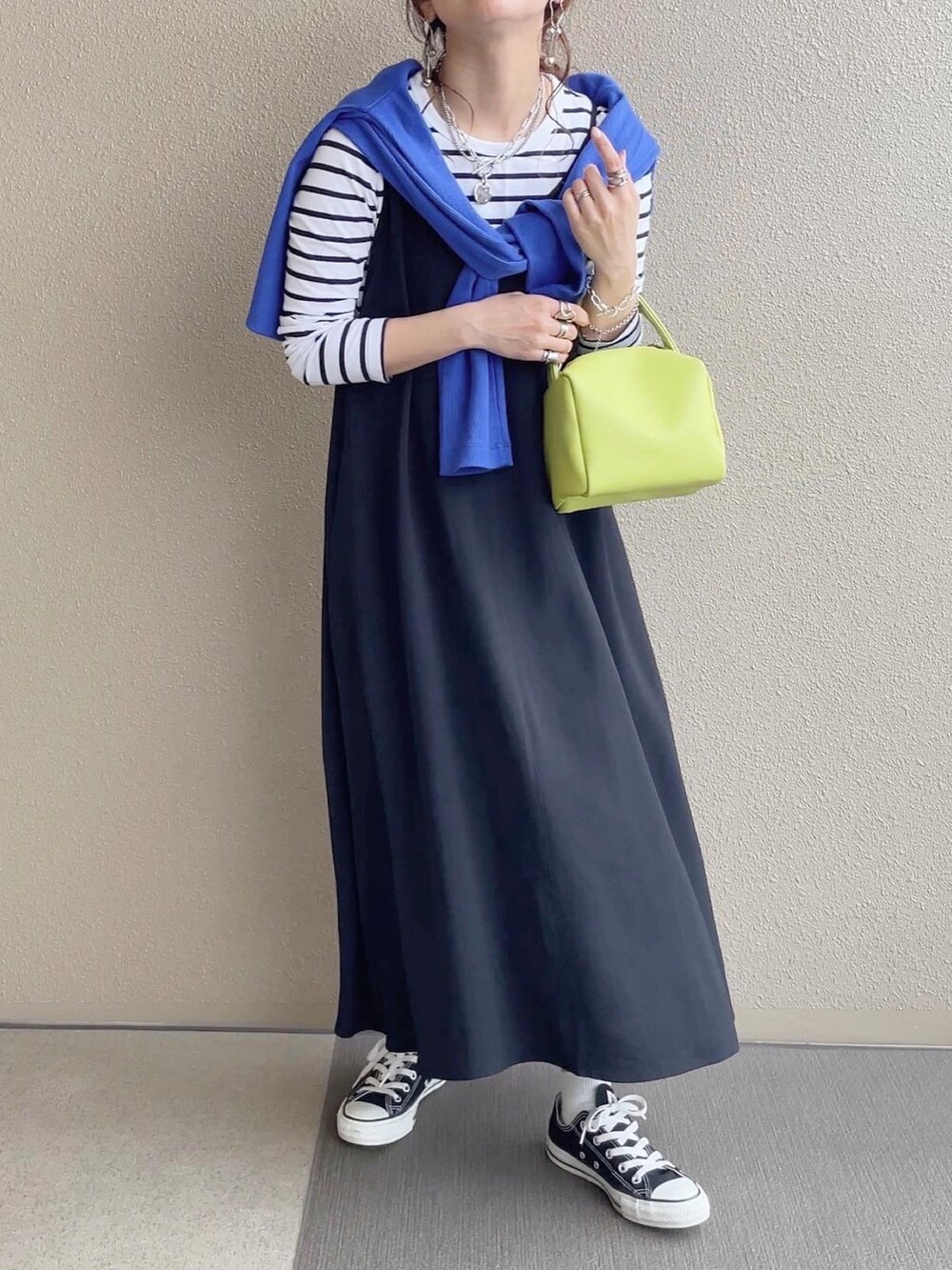 ブルー系のカーディガン/ボレロ、ブルー系のデニムパンツ、ブラック系のワンピースを着用したレディースの春コーディネートの5枚目の写真