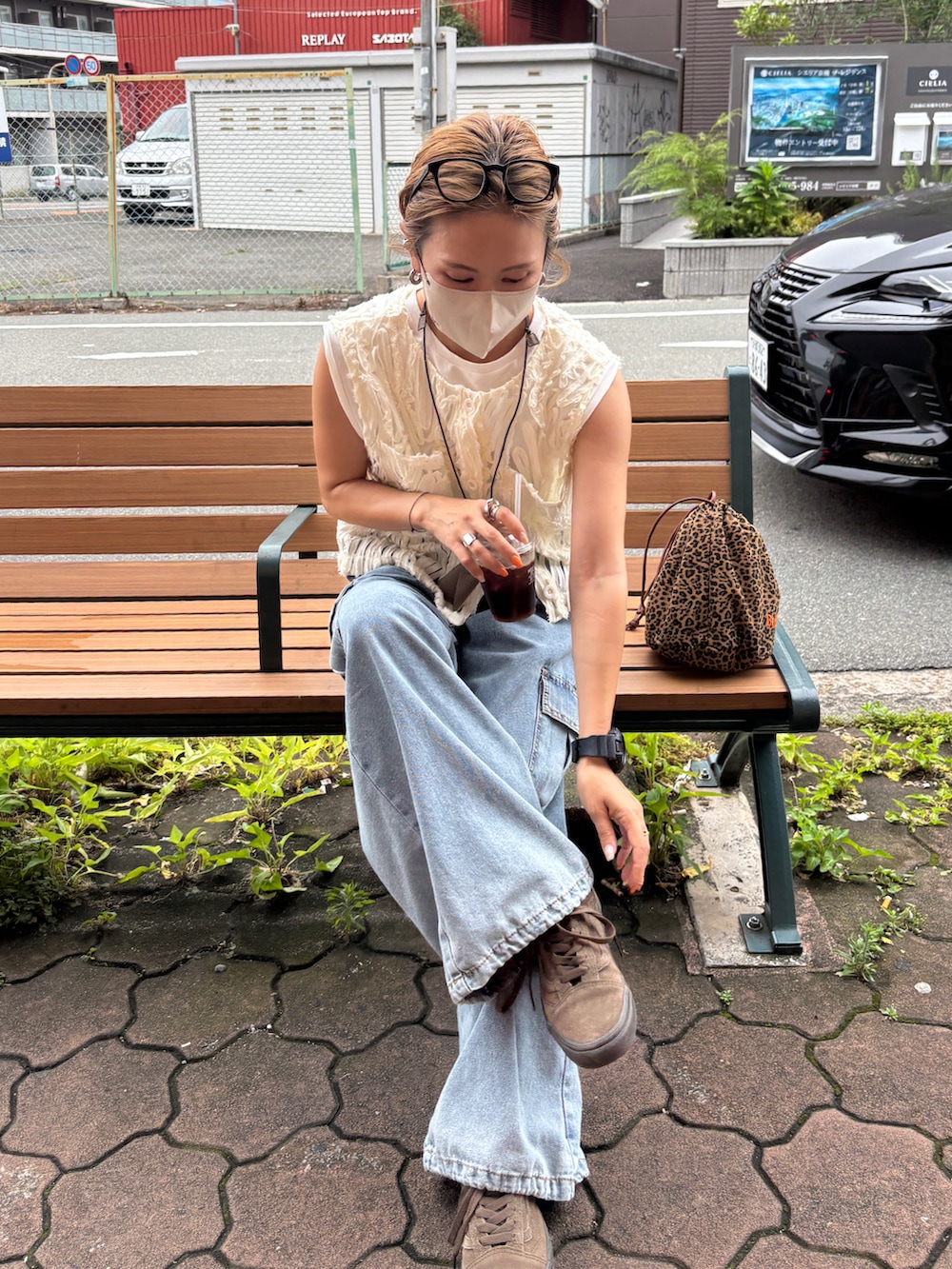 ブルー系のデニムパンツ、ホワイト系のベスト、その他のショルダーバッグを着用したレディースの夏コーディネートの4枚目の写真