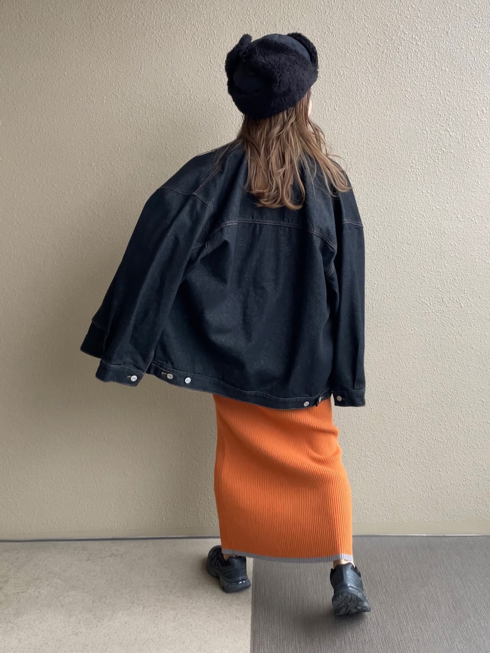 オレンジ系のスカート、ブラック系のスウェット、ブラック系のデニムジャケットを着用したレディースの秋コーディネートの4枚目の写真