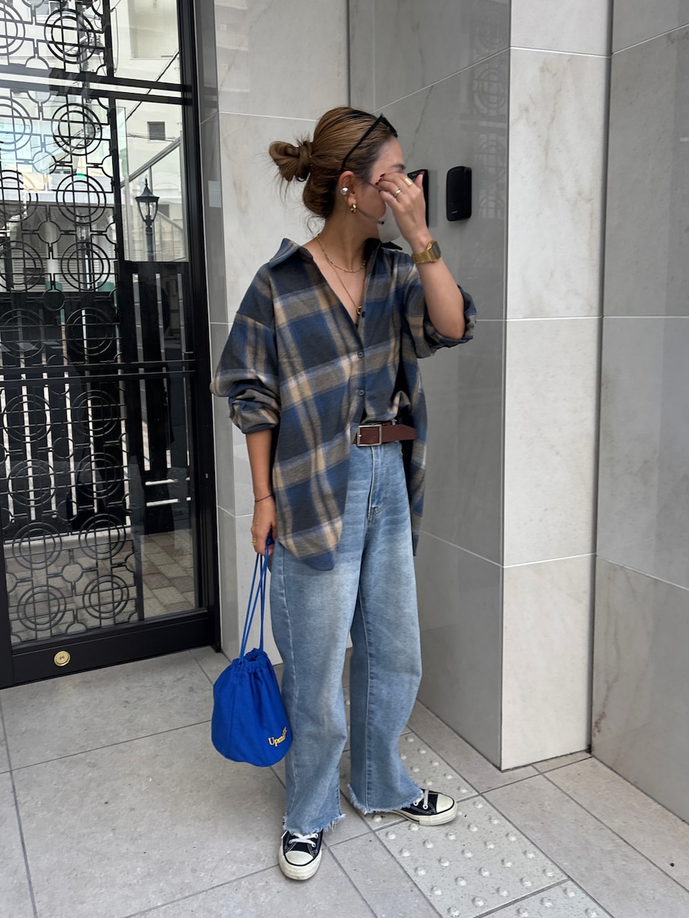 ベージュ系のシャツ/ブラウス、ブルー系のデニムパンツ、ブルー系のショルダーバッグを着用したレディースの秋コーディネートの4枚目の写真