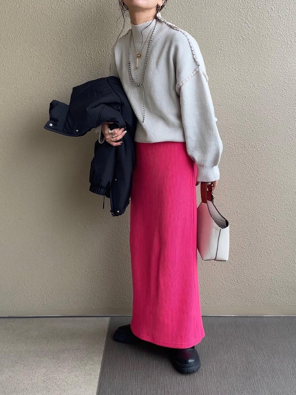 ベージュ系のニット/セーター、ベージュ系のスカート、グリーン系のダウンジャケット/コートを着用したレディースの冬コーディネートの5枚目の写真