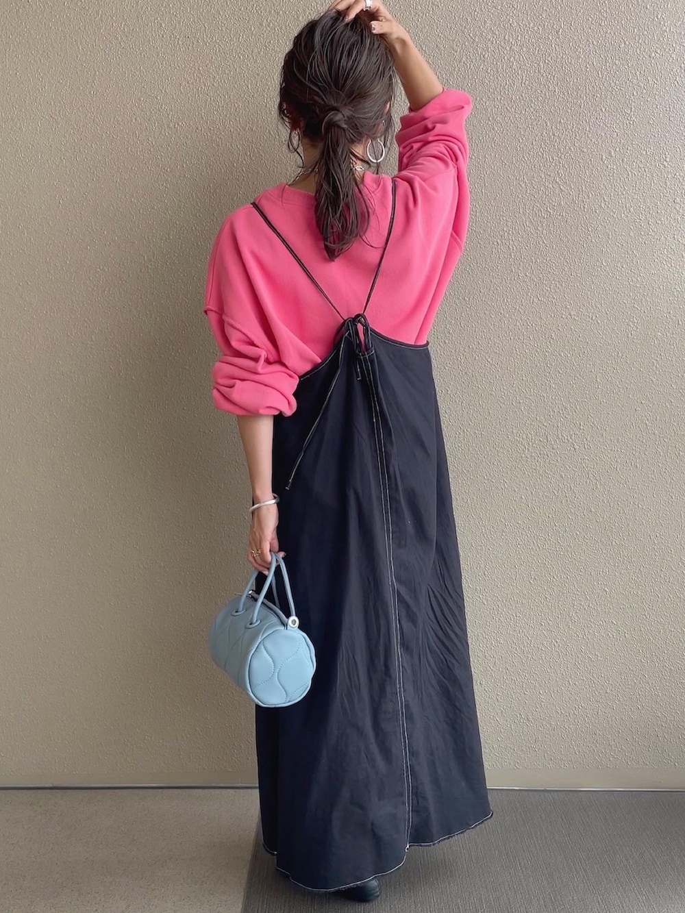 ピンク系のスウェット、ホワイト系のベスト、ブルー系のショルダーバッグを着用したレディースの秋コーディネートの4枚目の写真