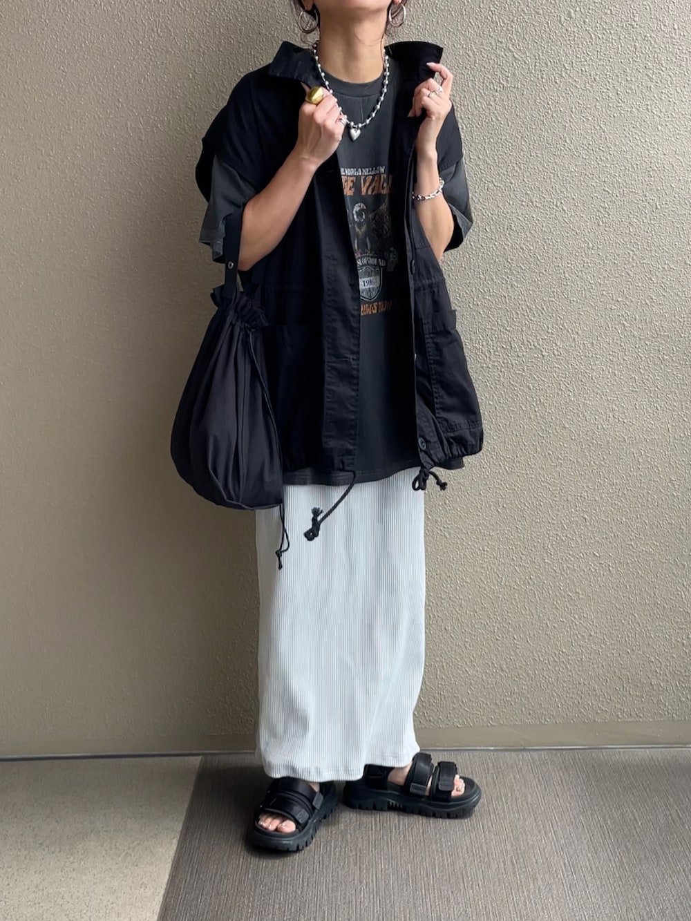 ブラック系のTシャツ/カットソー、オレンジ系のスラックス、ブラック系のワンピースを着用したレディースの夏コーディネートの5枚目の写真