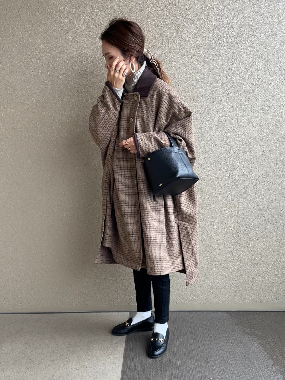 ホワイト系のニット/セーター、ブラック系のデニムパンツ、ブラック系のその他シューズを着用したレディースの秋コーディネートの3枚目の写真