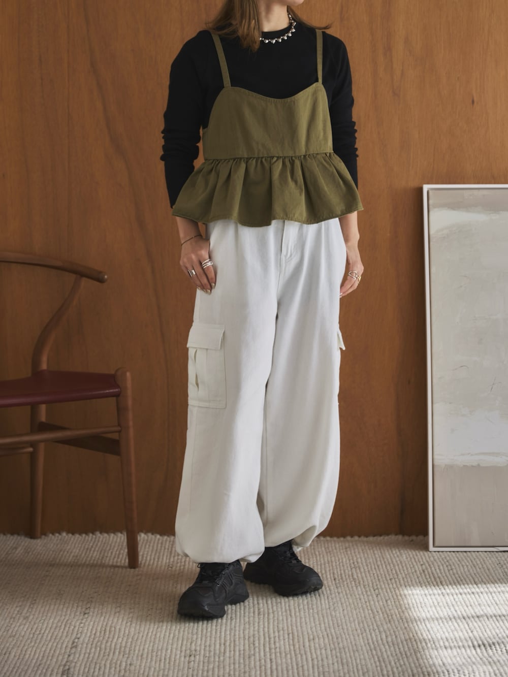 グリーン系のキャミソール、ブラック系のTシャツ/カットソー、ホワイト系のデニムパンツを着用したレディースの春コーディネートの4枚目の写真