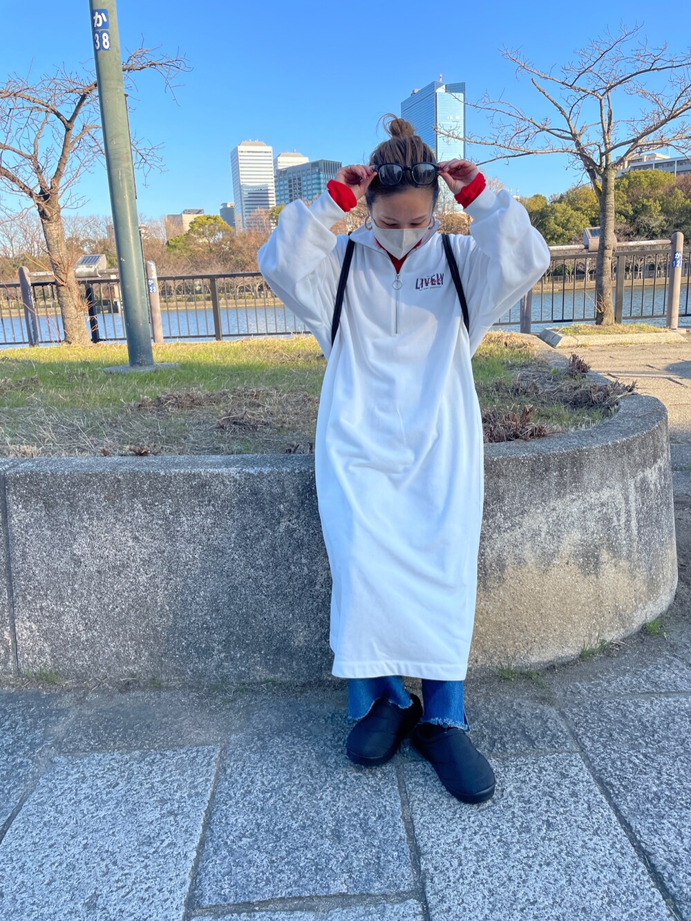 ホワイト系のワンピース/ドレス、レッド系のTシャツ/カットソー、ブルー系のデニムパンツを着用したレディースの冬コーディネートの2枚目の写真