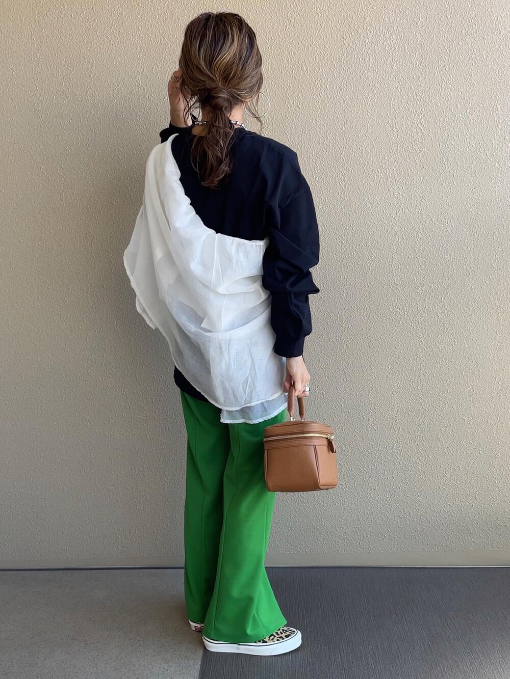 ベージュ系のスウェット、グリーン系のベスト、グリーン系のスラックスを着用したレディースの秋コーディネートの5枚目の写真