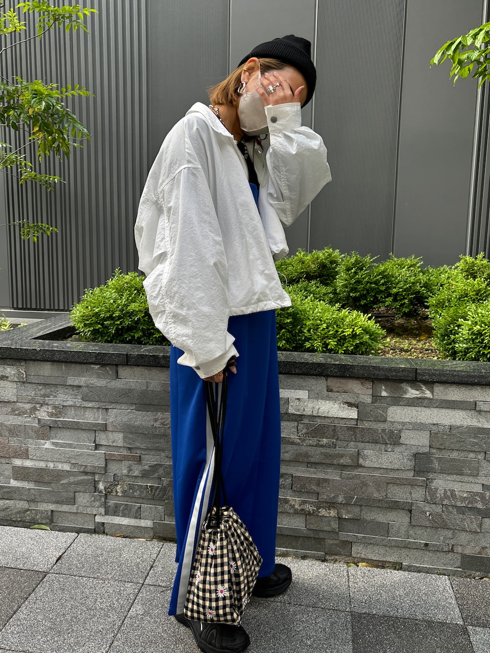 ブルー系のワンピース、ホワイト系のナイロンジャケットを着用したレディースの春コーディネートの5枚目の写真