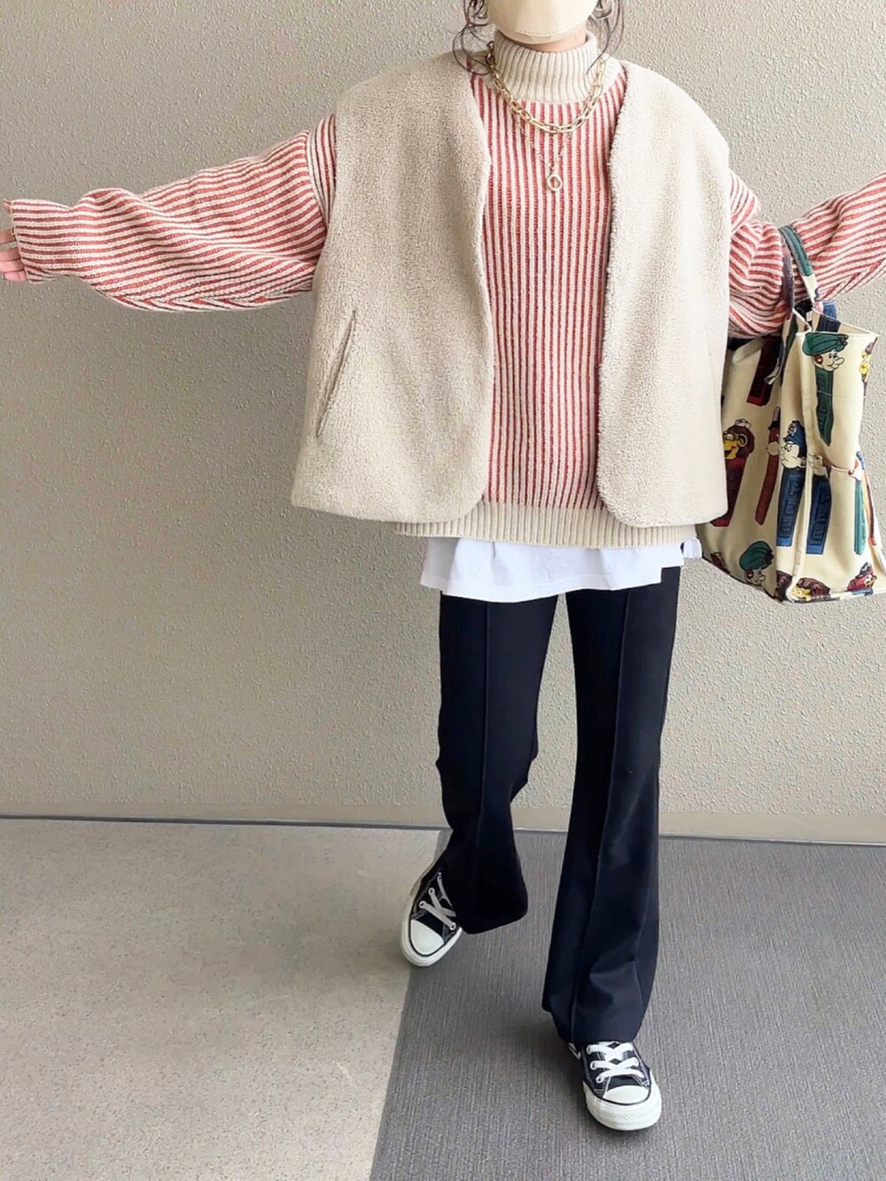 オレンジ系のニット/セーター、ブラック系のその他パンツ、ホワイト系のトートバッグを着用したレディースの冬コーディネートの2枚目の写真