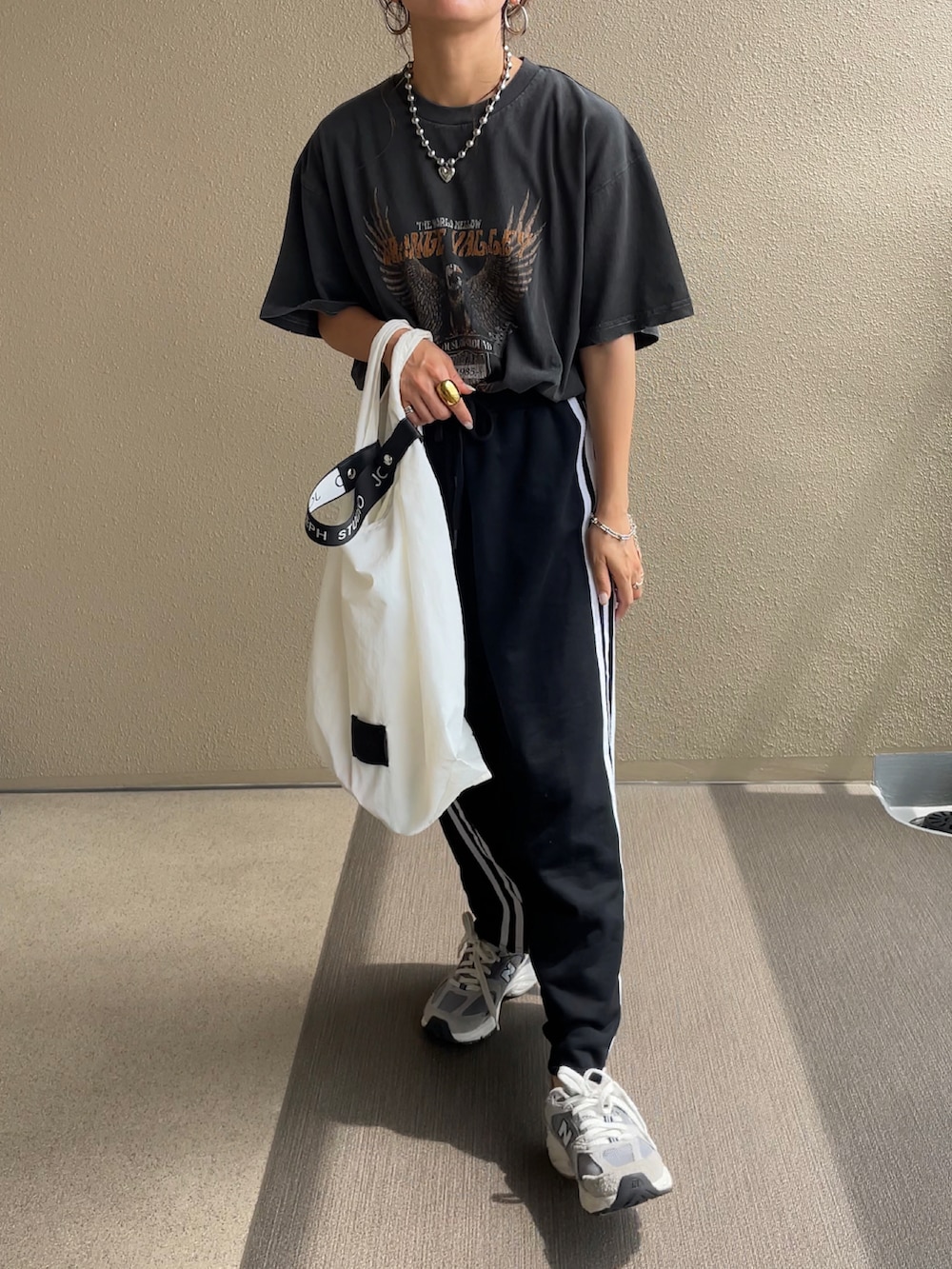 ブラック系のTシャツ/カットソー、オレンジ系のスラックス、ブラック系のワンピースを着用したレディースの夏コーディネートの2枚目の写真