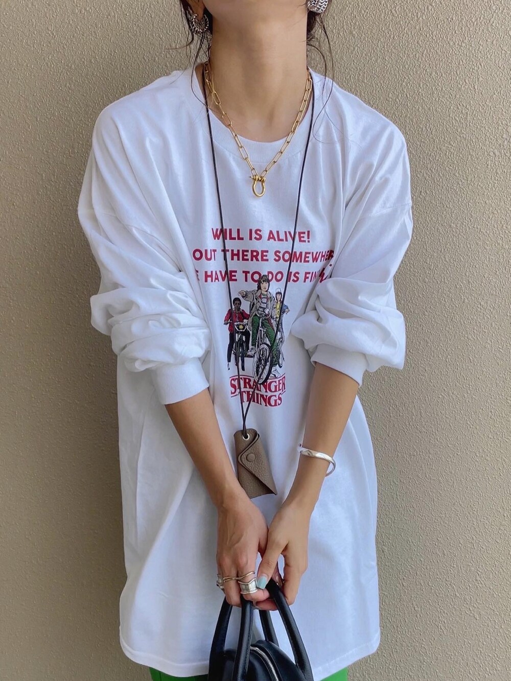 グリーン系のスラックス、ホワイト系のTシャツ/カットソーを着用したレディースの秋コーディネートの4枚目の写真