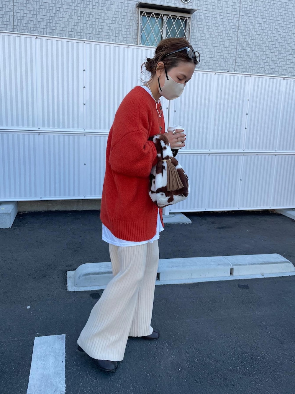 オレンジ系のカーディガン/ボレロ、ホワイト系のTシャツ/カットソー、ベージュ系のその他パンツを着用したレディースの冬コーディネートの2枚目の写真