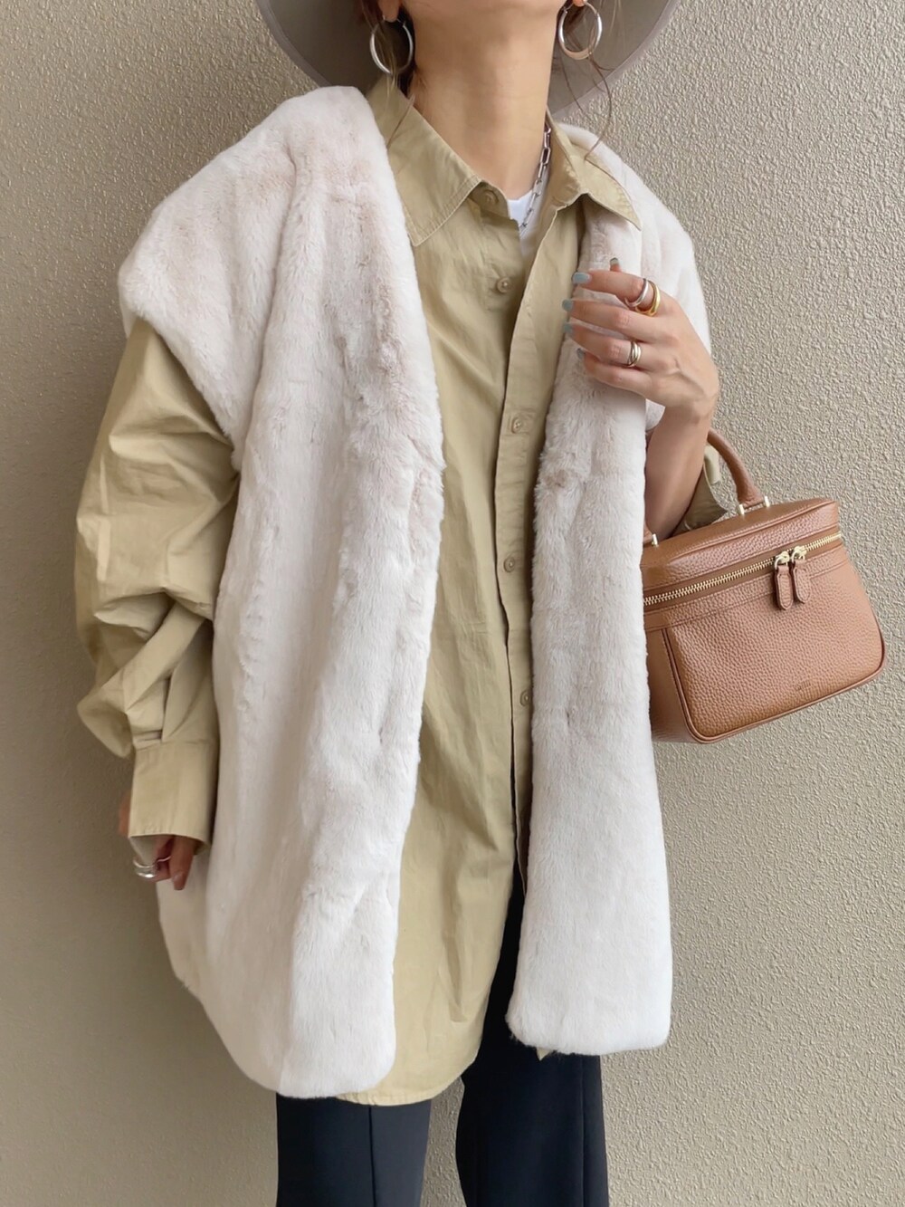 ホワイト系のベスト、ベージュ系のシャツ/ブラウス、ブラック系のスラックスを着用したレディースの秋コーディネートの5枚目の写真