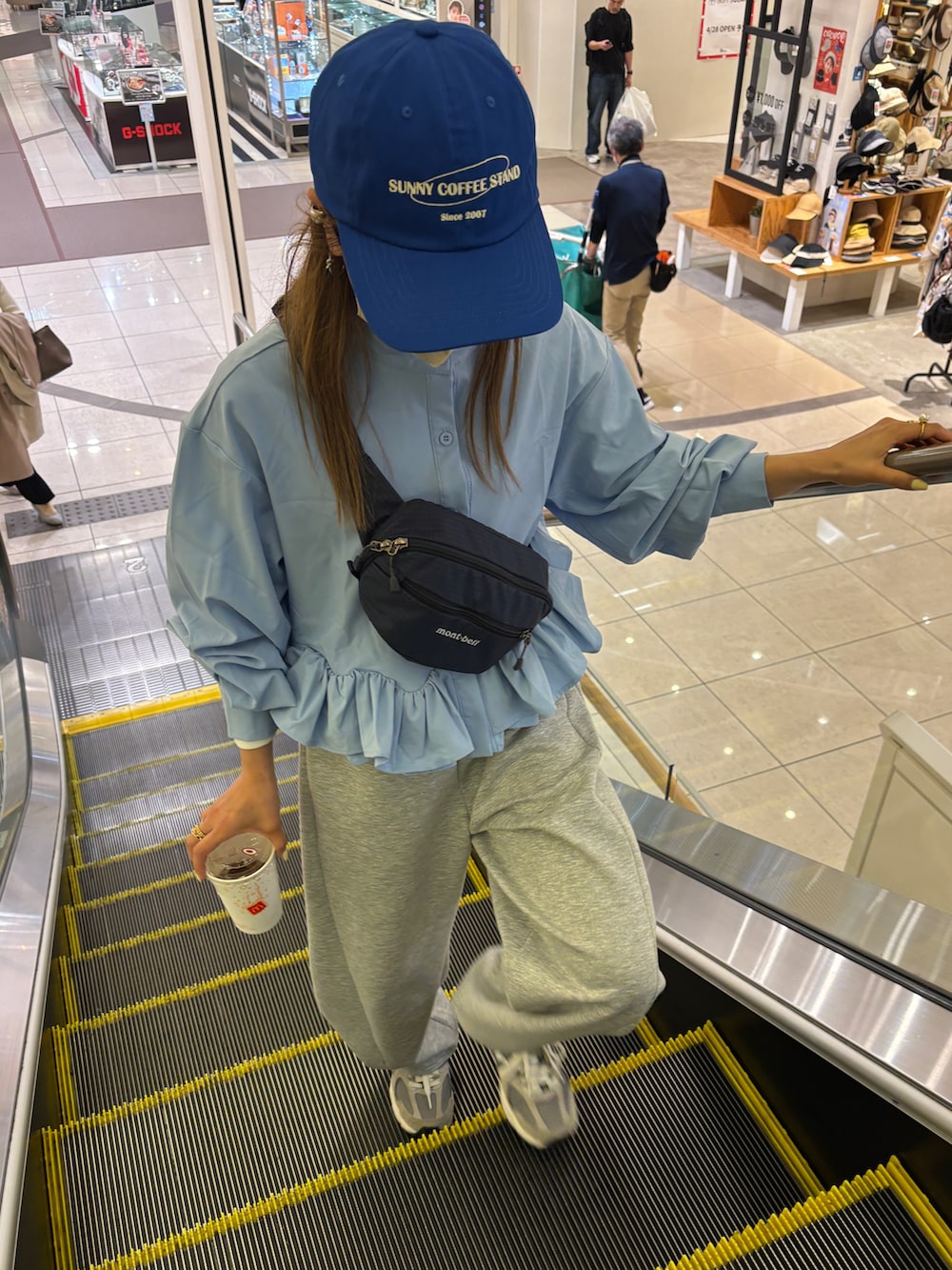 グレー系のセットアップ、ブルー系のTシャツ/カットソー、ブルー系のキャップを着用したレディースの春コーディネートの4枚目の写真