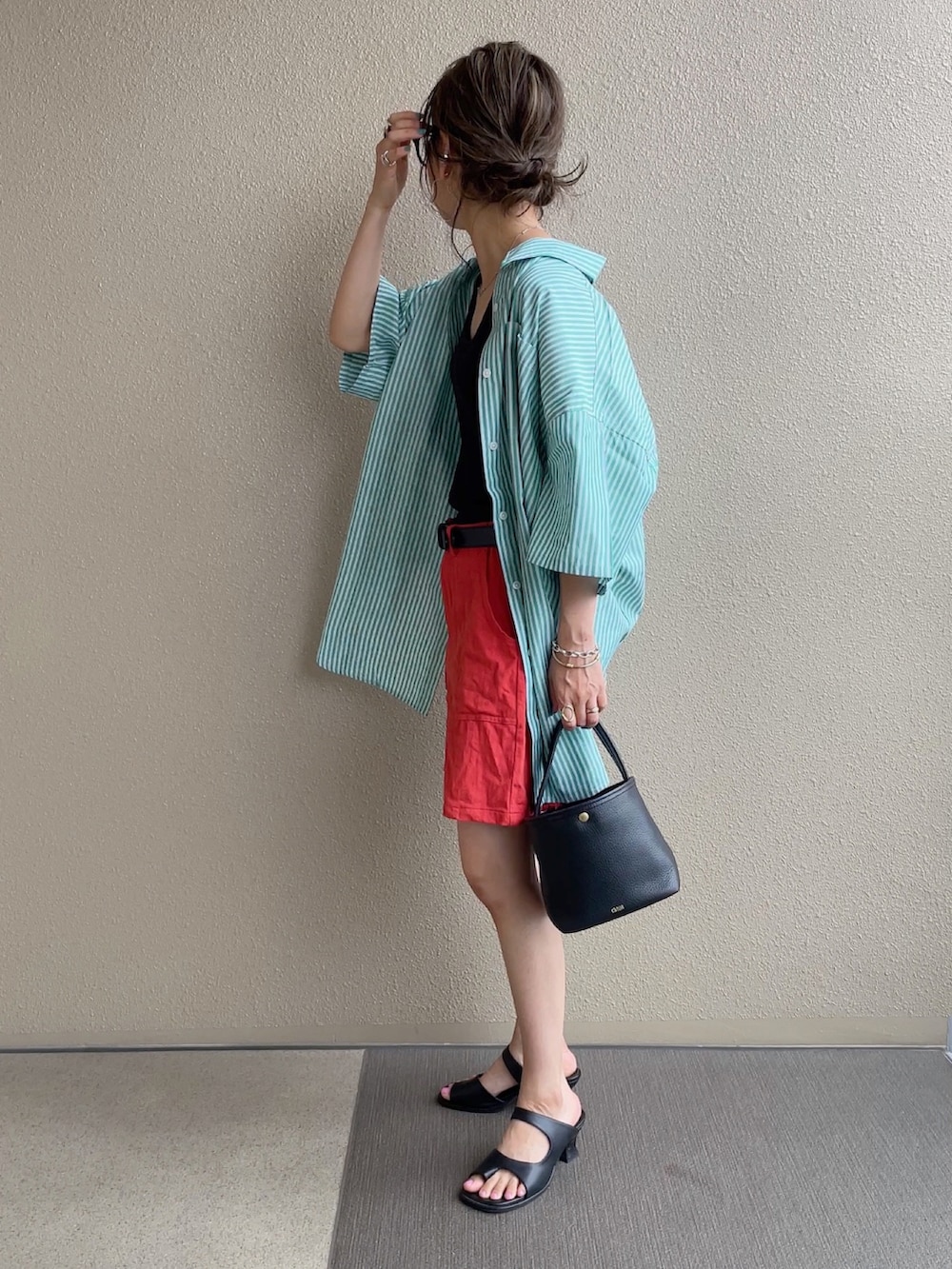 グリーン系のシャツ/ブラウス、オレンジ系のその他パンツ、ブルー系のデニムパンツを着用したレディースの春コーディネートの5枚目の写真