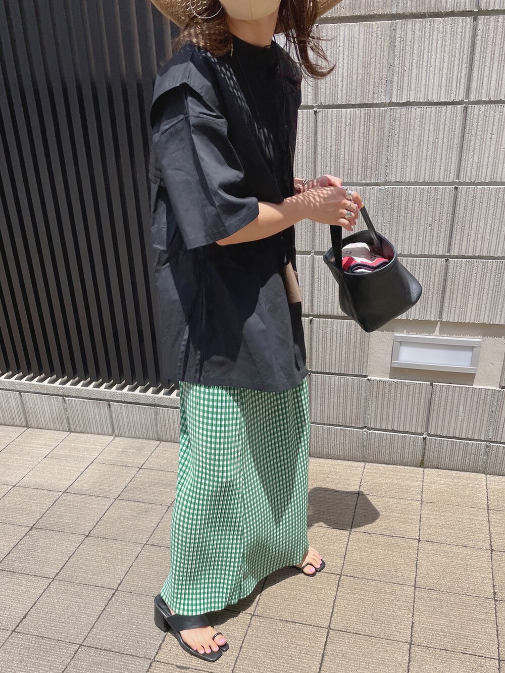 ブラック系のシャツ/ブラウス、グリーン系のスカート、ベージュ系のハットを着用したレディースの夏コーディネートの5枚目の写真