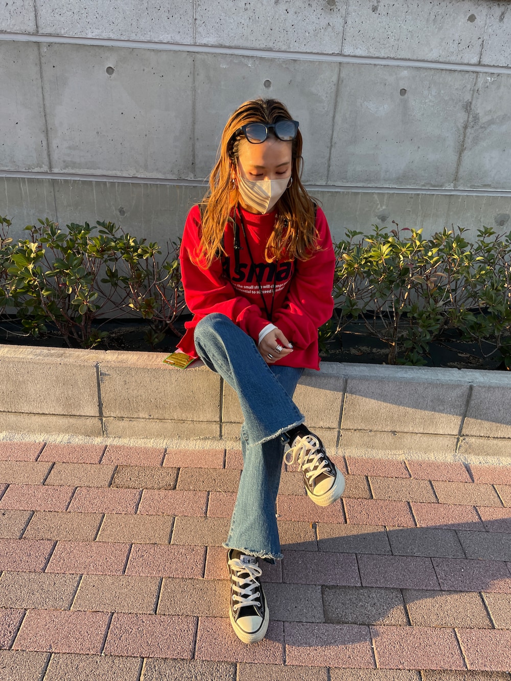 レッド系のスウェット、ブルー系のデニムパンツを着用したレディースの冬コーディネートの3枚目の写真