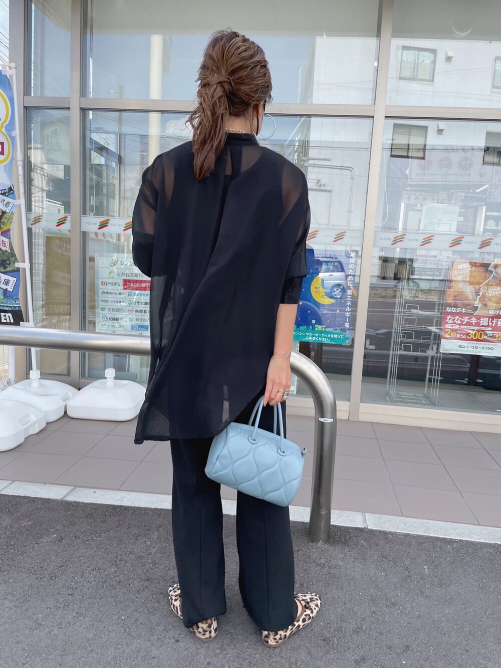 ブラック系のスラックス、ブラック系のTシャツ/カットソー、ブルー系のショルダーバッグを着用したレディースの秋コーディネートの3枚目の写真