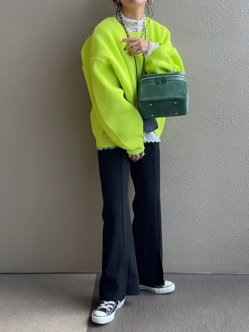 グリーン系のニット/セーター、ホワイト系のTシャツ/カットソー、ブラック系のスラックスを着用したレディースの秋コーディネートの3枚目の写真