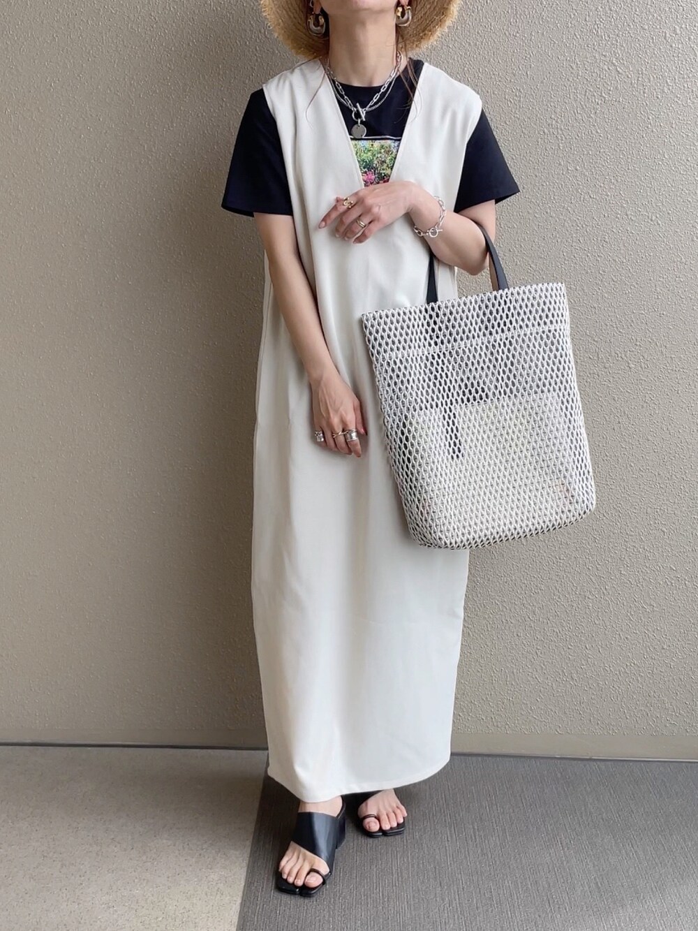 ブラック系のTシャツ/カットソー、ピンク系のシャツ/ブラウス、ベージュ系のジャンパースカートを着用したレディースの春コーディネートの2枚目の写真