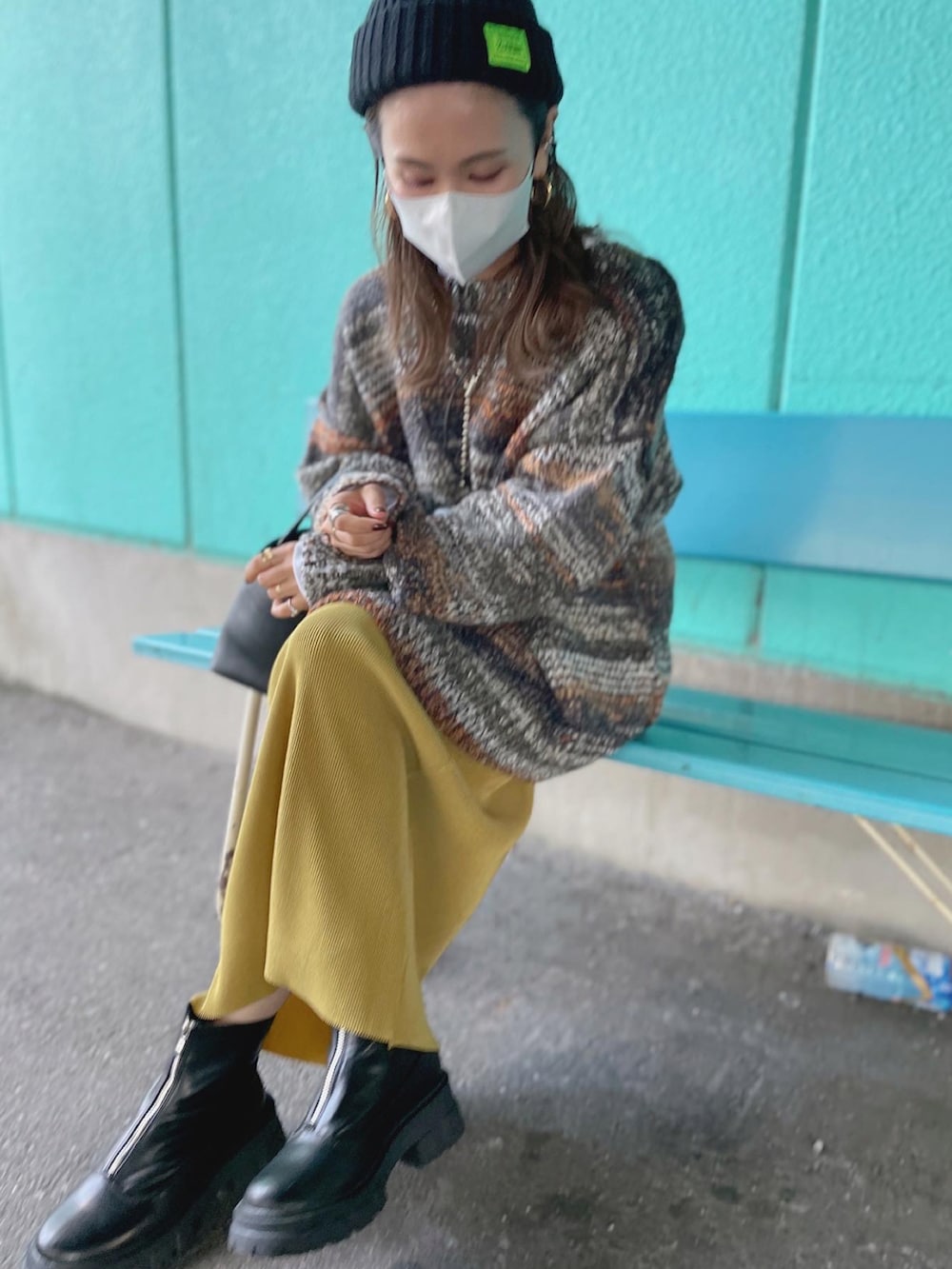 グリーン系のカーディガン/ボレロ、イエロー系のスカートを着用したレディースの秋コーディネートの3枚目の写真