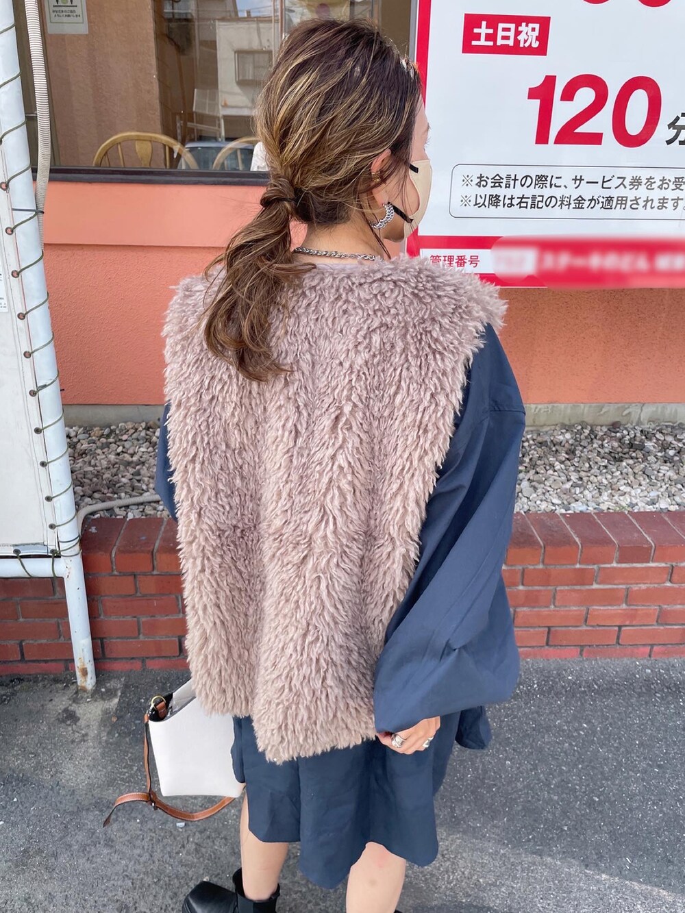 ベージュ系のベスト、ブルー系のワンピース/ドレス、ブラック系のブーツを着用したレディースの秋コーディネートの4枚目の写真