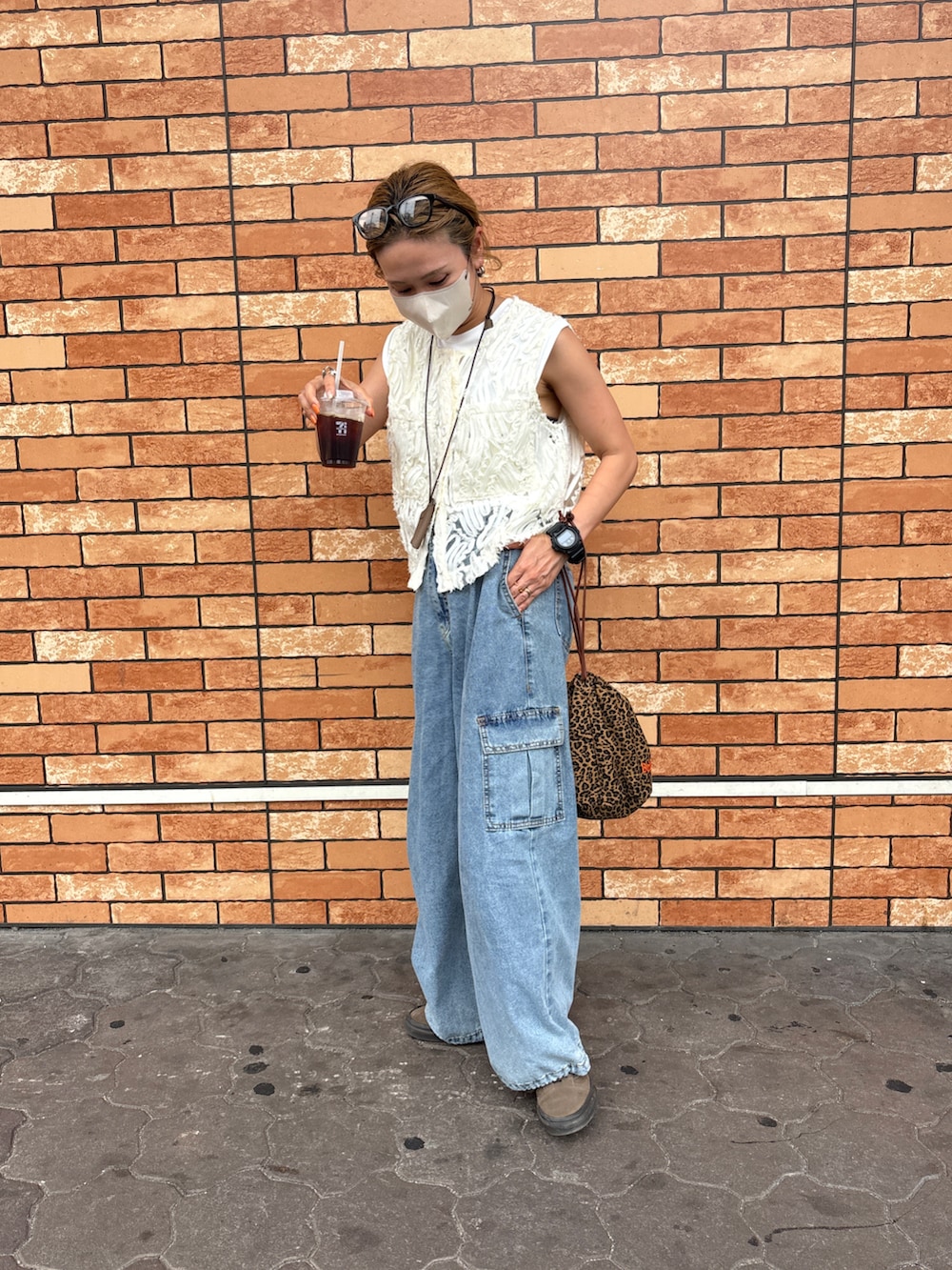 ブルー系のデニムパンツ、ホワイト系のベスト、その他のショルダーバッグを着用したレディースの夏コーディネートの5枚目の写真