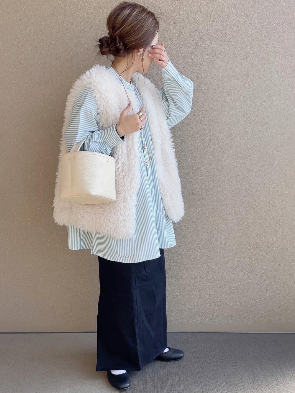 ブラック系のスカート、グリーン系のシャツ/ブラウス、ホワイト系のベストを着用したレディースの冬コーディネートの2枚目の写真