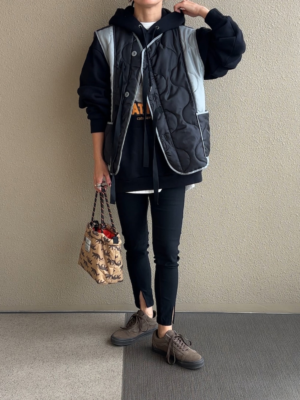 ブラック系のその他アウター、ブラック系のパーカー、ベージュ系のショルダーバッグを着用したレディースの秋コーディネートの2枚目の写真