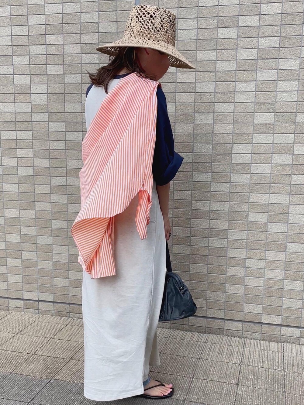 オレンジ系のシャツ/ブラウス、ベージュ系のハットを着用したレディースの夏コーディネートの5枚目の写真