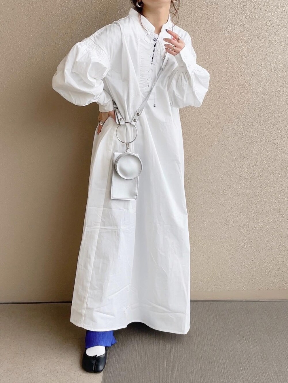 ホワイト系のワンピース、ブルー系のその他パンツ、ホワイト系のショルダーバッグを着用したレディースの冬コーディネートの4枚目の写真