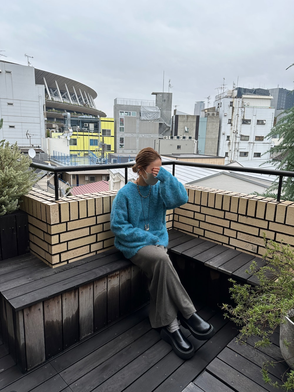 ホワイト系のモッズコート、ブルー系のニット/セーター、グレー系のワンピースを着用したレディースの冬コーディネートの3枚目の写真