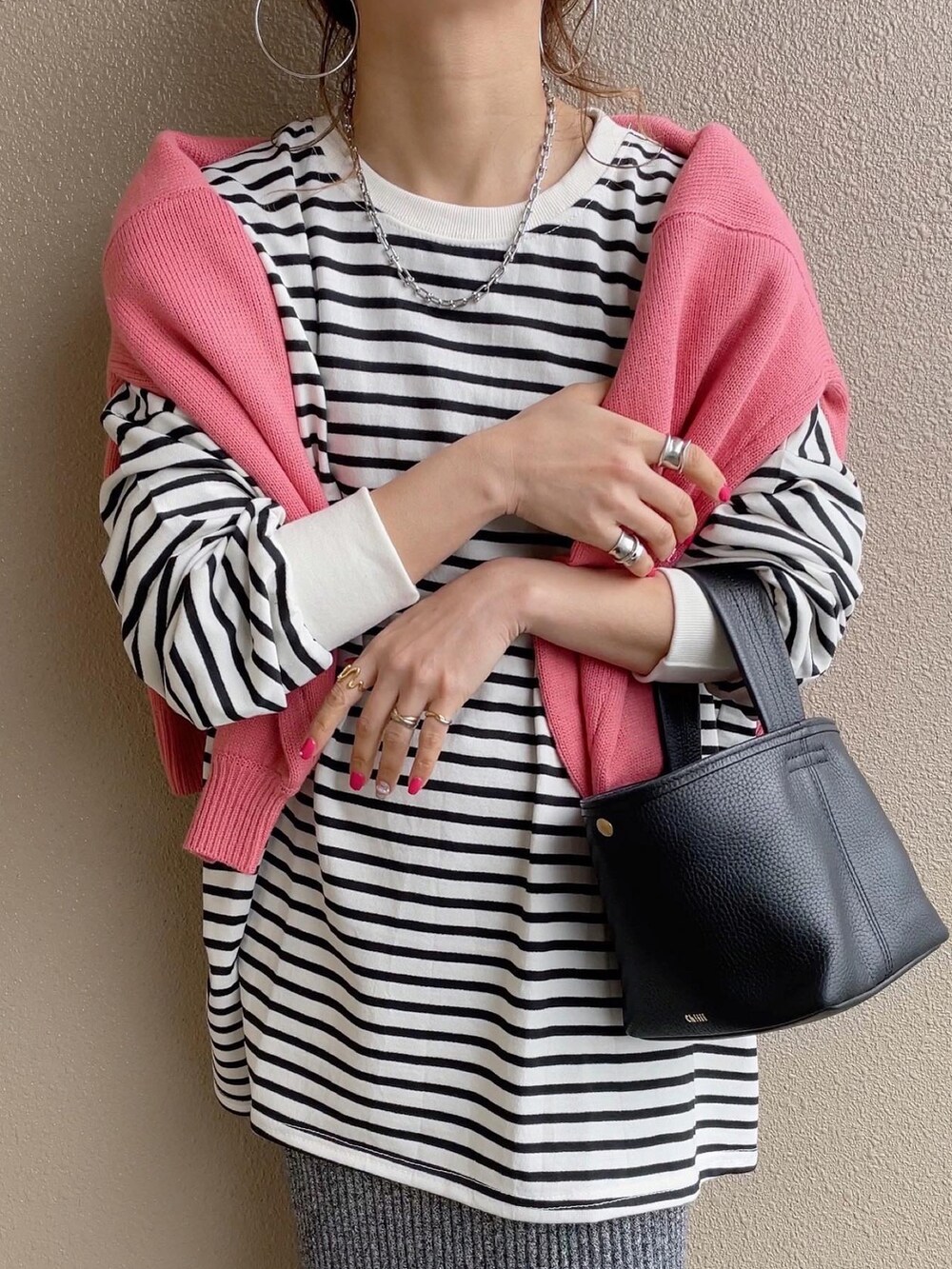 ブラック系のTシャツ/カットソー、ブラック系のスカート、オレンジ系のその他パンツを着用したレディースの春コーディネートの5枚目の写真