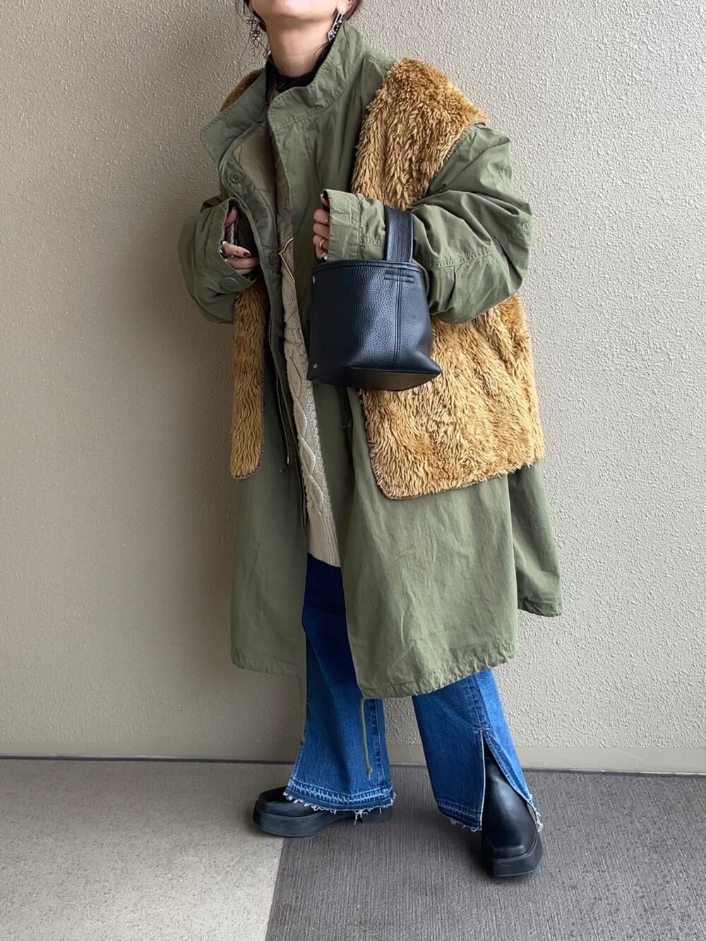 ブルー系のデニムパンツ、ホワイト系のニット/セーター、ブラック系のブーツを着用したレディースの冬コーディネートの3枚目の写真