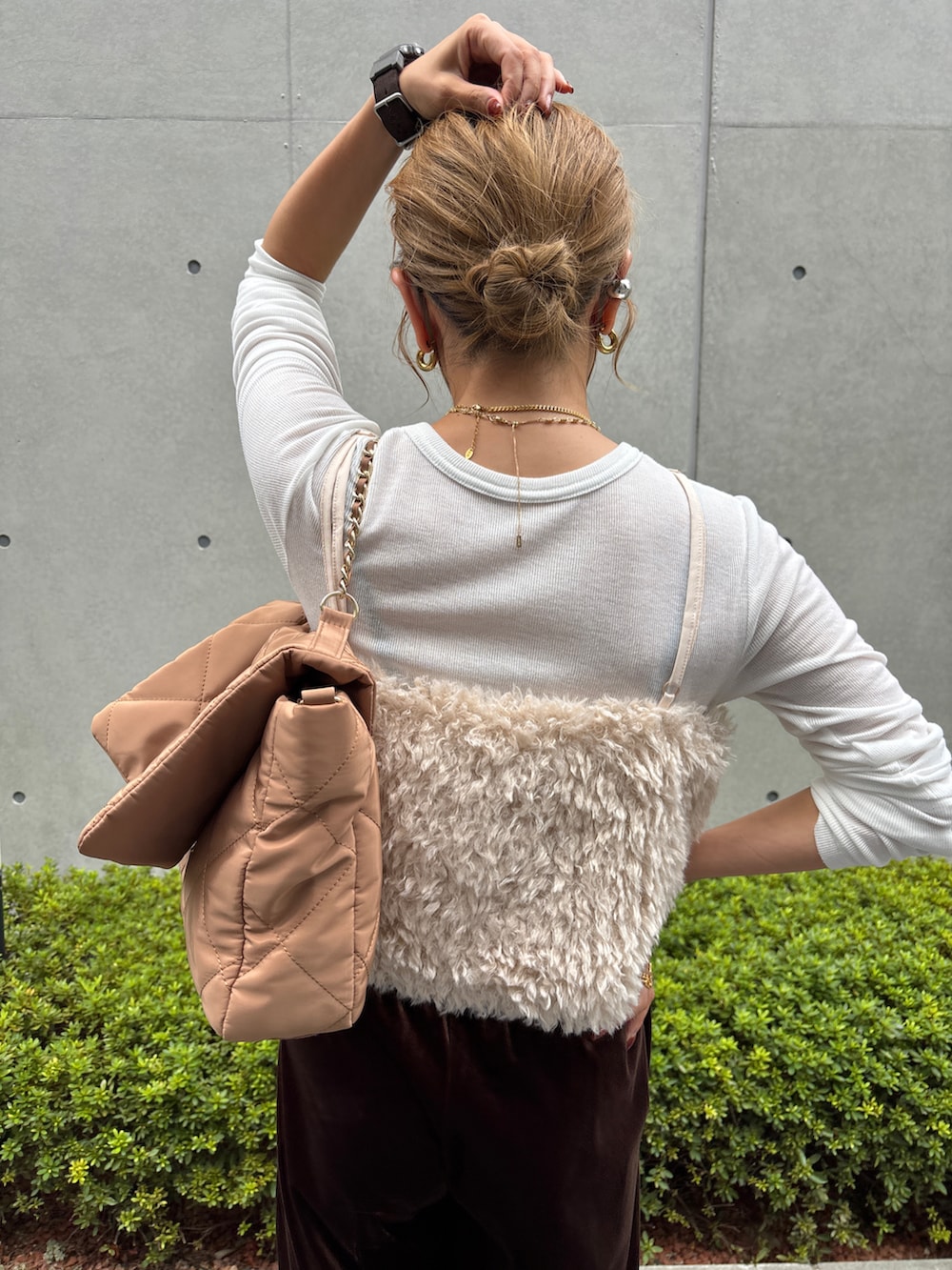 ホワイト系のベスト、ブラウン系のスニーカー、ブラウン系のパンツを着用したレディースの秋コーディネートの4枚目の写真